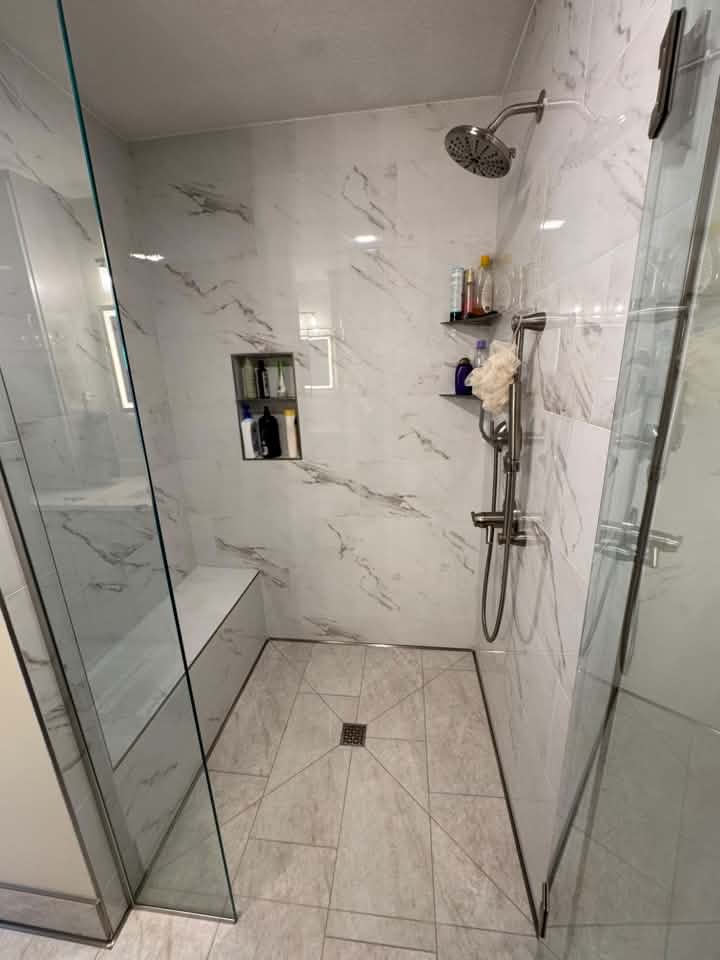 Marble tile shower installation with shower seat 